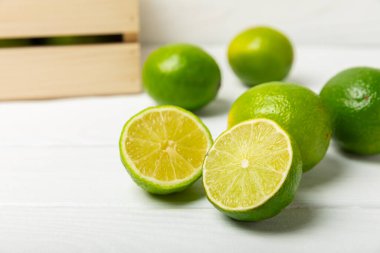 Tahta bir masada taze kireç. Masadaki bütün limon ve dilimler bir kasede. Citrus. C vitamini diyeti. Tropik meyveler. Yaz ferahlatıcı limonata ya da mojito konsepti. Mesaj için yer var. Boşluğu kopyala.