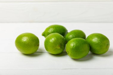 Tahta bir masada taze kireç. Masadaki bütün limon ve dilimler bir kasede. Citrus. C vitamini diyeti. Tropik meyveler. Yaz ferahlatıcı limonata ya da mojito konsepti. Mesaj için yer var. Boşluğu kopyala.