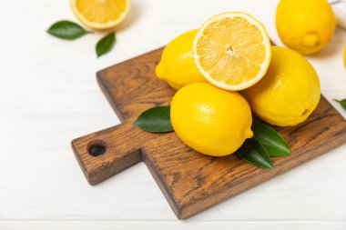 Tahta bir masada limon. Bir dilim taze limon. Turunçgil yapraklı taze limon. Limon suyu. Yemek ve içecek malzemeleri hazırlanıyor. Sağlıklı beslenme. Metin için C vitamini alanı.
