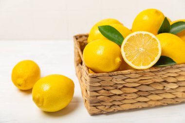 Tahta bir masada limon. Bir dilim taze limon. Turunçgil yapraklı taze limon. Limon suyu. Yemek ve içecek malzemeleri hazırlanıyor. Sağlıklı beslenme. Metin için C vitamini alanı.