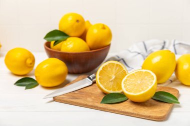 Tahta bir masada limon. Bir dilim taze limon. Turunçgil yapraklı taze limon. Limon suyu. Yemek ve içecek malzemeleri hazırlanıyor. Sağlıklı beslenme. Metin için C vitamini alanı.
