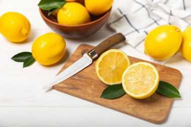 Tahta bir masada limon. Bir dilim taze limon. Turunçgil yapraklı taze limon. Limon suyu. Yemek ve içecek malzemeleri hazırlanıyor. Sağlıklı beslenme. Metin için C vitamini alanı.