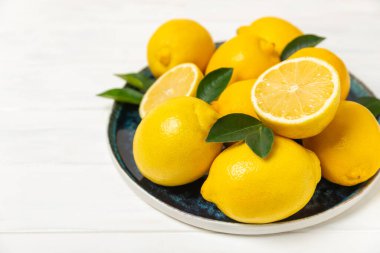 Tahta bir masada limon. Bir dilim taze limon. Turunçgil yapraklı taze limon. Limon suyu. Yemek ve içecek malzemeleri hazırlanıyor. Sağlıklı beslenme. Metin için C vitamini alanı.