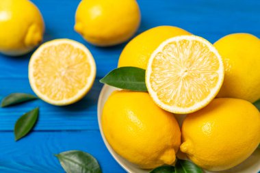 Tahta bir masada limon. Bir dilim taze limon. Turunçgil yapraklı taze limon. Limon suyu. Yemek ve içecek malzemeleri hazırlanıyor. Sağlıklı beslenme. Metin için C vitamini alanı.