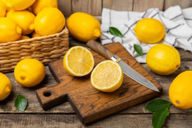 Tahta bir masada limon. Bir dilim taze limon. Turunçgil yapraklı taze limon. Limon suyu. Yemek ve içecek malzemeleri hazırlanıyor. Sağlıklı beslenme. Metin için C vitamini alanı.