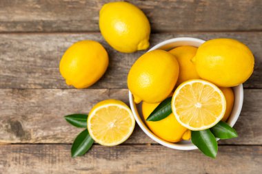 Tahta bir masada limon. Bir dilim taze limon. Turunçgil yapraklı taze limon. Limon suyu. Yemek ve içecek malzemeleri hazırlanıyor. Sağlıklı beslenme. Metin için C vitamini alanı.