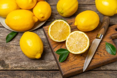 Tahta bir masada limon. Bir dilim taze limon. Turunçgil yapraklı taze limon. Limon suyu. Yemek ve içecek malzemeleri hazırlanıyor. Sağlıklı beslenme. Metin için C vitamini alanı.