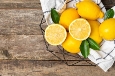 Tahta bir masada limon. Bir dilim taze limon. Turunçgil yapraklı taze limon. Limon suyu. Yemek ve içecek malzemeleri hazırlanıyor. Sağlıklı beslenme. Metin için C vitamini alanı.