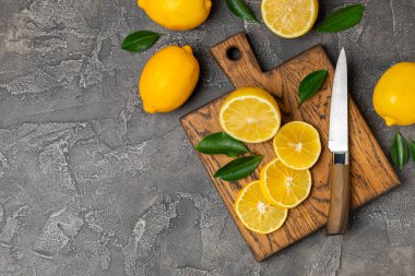 Tahta bir masada limon. Bir dilim taze limon. Turunçgil yapraklı taze limon. Limon suyu. Yemek ve içecek malzemeleri hazırlanıyor. Sağlıklı beslenme. Metin için C vitamini alanı.