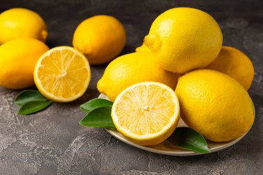 Tahta bir masada limon. Bir dilim taze limon. Turunçgil yapraklı taze limon. Limon suyu. Yemek ve içecek malzemeleri hazırlanıyor. Sağlıklı beslenme. Metin için C vitamini alanı.
