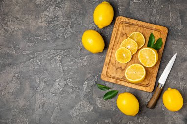 Tahta bir masada limon. Bir dilim taze limon. Turunçgil yapraklı taze limon. Limon suyu. Yemek ve içecek malzemeleri hazırlanıyor. Sağlıklı beslenme. Metin için C vitamini alanı.