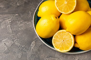 Tahta bir masada limon. Bir dilim taze limon. Turunçgil yapraklı taze limon. Limon suyu. Yemek ve içecek malzemeleri hazırlanıyor. Sağlıklı beslenme. Metin için C vitamini alanı.