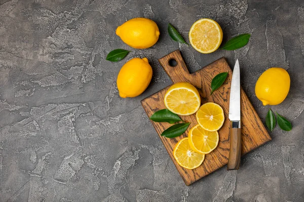 Tahta bir masada limon. Bir dilim taze limon. Turunçgil yapraklı taze limon. Limon suyu. Yemek ve içecek malzemeleri hazırlanıyor. Sağlıklı beslenme. Metin için C vitamini alanı.