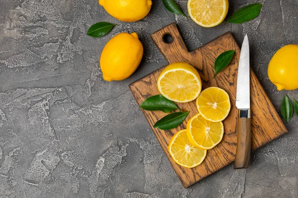 Tahta bir masada limon. Bir dilim taze limon. Turunçgil yapraklı taze limon. Limon suyu. Yemek ve içecek malzemeleri hazırlanıyor. Sağlıklı beslenme. Metin için C vitamini alanı.