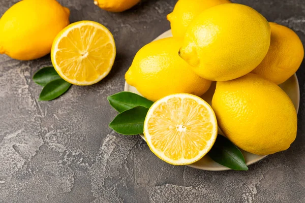 Tahta bir masada limon. Bir dilim taze limon. Turunçgil yapraklı taze limon. Limon suyu. Yemek ve içecek malzemeleri hazırlanıyor. Sağlıklı beslenme. Metin için C vitamini alanı.