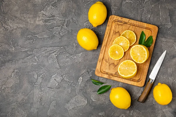 Tahta bir masada limon. Bir dilim taze limon. Turunçgil yapraklı taze limon. Limon suyu. Yemek ve içecek malzemeleri hazırlanıyor. Sağlıklı beslenme. Metin için C vitamini alanı.