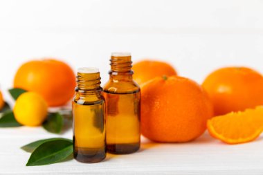 Tahta bir masada mandalina yağı. Bir şişe turunçgil yağı ve dilimlenmiş meyve. Mandalina kokulu mandalina yağı. Spa tedavileri için kozmetik yağı. Aromaterapi konsepti. Doğal kozmetikler. Geleneksel tıp. Metin için boşluk.