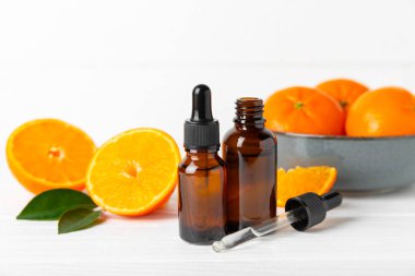 Tahta bir masada mandalina yağı. Bir şişe turunçgil yağı ve dilimlenmiş meyve. Mandalina kokulu mandalina yağı. Spa tedavileri için kozmetik yağı. Aromaterapi konsepti. Doğal kozmetikler. Geleneksel tıp. Metin için boşluk.