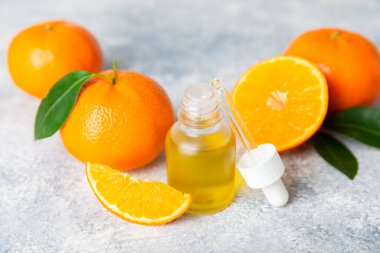 Tahta bir masada mandalina yağı. Bir şişe turunçgil yağı ve dilimlenmiş meyve. Mandalina kokulu mandalina yağı. Spa tedavileri için kozmetik yağı. Aromaterapi konsepti. Doğal kozmetikler. Geleneksel tıp. Metin için boşluk.