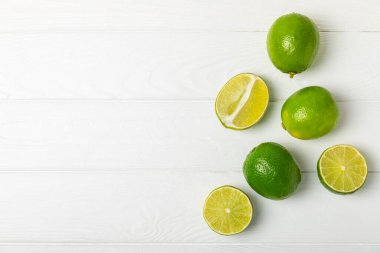 Tahta bir masada taze kireç. Masadaki bütün limon ve dilimler bir kasede. Citrus. C vitamini diyeti. Tropik meyveler. Yaz ferahlatıcı limonata ya da mojito konsepti. Mesaj için yer var. Boşluğu kopyala.
