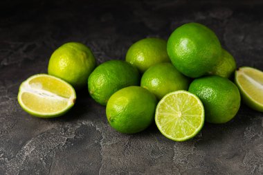 Tahta bir masada taze kireç. Masadaki bütün limon ve dilimler bir kasede. Citrus. C vitamini diyeti. Tropik meyveler. Yaz ferahlatıcı limonata ya da mojito konsepti. Mesaj için yer var. Boşluğu kopyala.