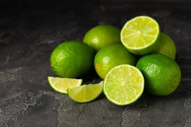Tahta bir masada taze kireç. Masadaki bütün limon ve dilimler bir kasede. Citrus. C vitamini diyeti. Tropik meyveler. Yaz ferahlatıcı limonata ya da mojito konsepti. Mesaj için yer var. Boşluğu kopyala.