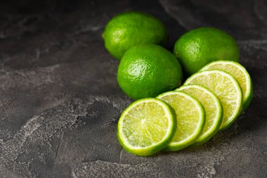Tahta bir masada taze kireç. Masadaki bütün limon ve dilimler bir kasede. Citrus. C vitamini diyeti. Tropik meyveler. Yaz ferahlatıcı limonata ya da mojito konsepti. Mesaj için yer var. Boşluğu kopyala.