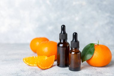Tahta bir masada mandalina yağı. Bir şişe turunçgil yağı ve dilimlenmiş meyve. Mandalina kokulu mandalina yağı. Spa tedavileri için kozmetik yağı. Aromaterapi konsepti. Doğal kozmetikler. Geleneksel tıp. Metin için boşluk.