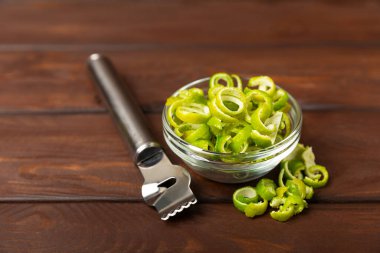 Masanın arka planında taze kireç. Bir kasede tam limon ve dilimler. Citrus. C vitamini diyeti. Tropik meyveler. Yaz ferahlatıcı limonata ya da mojito konsepti. Düz yatıyordu. Mesaj için yer var. Kokteyl dekoru. Pişirme malzemesi.