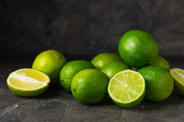 Tahta bir masada taze kireç. Masadaki bütün limon ve dilimler bir kasede. Citrus. C vitamini diyeti. Tropik meyveler. Yaz ferahlatıcı limonata ya da mojito konsepti. Mesaj için yer var. Boşluğu kopyala.