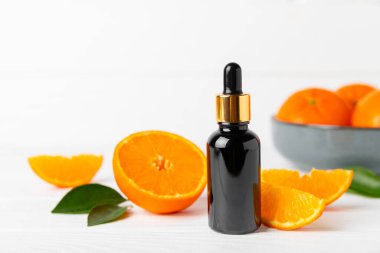 Tahta bir masada mandalina yağı. Bir şişe turunçgil yağı ve dilimlenmiş meyve. Mandalina kokulu mandalina yağı. Spa tedavileri için kozmetik yağı. Aromaterapi konsepti. Doğal kozmetikler. Geleneksel tıp. Metin için boşluk.