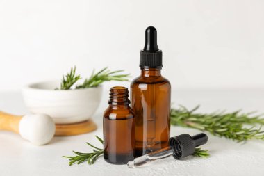 Dokulu bir arka planda biberiye yağı. Yakınlarda taze yaprakları olan biberiye yağı. Yeşil biberiye filizi. Doğal ilaçlar, organik saç ürünleri, cilt bakımı, spa terapisi. Güzellik konsepti. Kozmetik serumu, özü. Metin için boşluk.