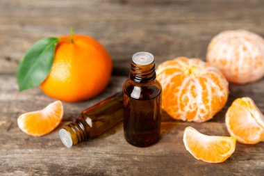 Tahta bir masada mandalina yağı. Bir şişe turunçgil yağı ve dilimlenmiş meyve. Mandalina kokulu mandalina yağı. Spa tedavileri için kozmetik yağı. Aromaterapi konsepti. Doğal kozmetikler. Geleneksel tıp. Metin için boşluk.