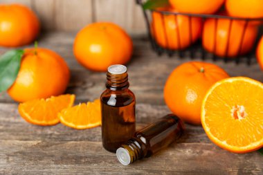 Tahta bir masada mandalina yağı. Bir şişe turunçgil yağı ve dilimlenmiş meyve. Mandalina kokulu mandalina yağı. Spa tedavileri için kozmetik yağı. Aromaterapi konsepti. Doğal kozmetikler. Geleneksel tıp. Metin için boşluk.