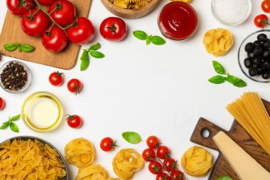 Farklı türde makarna, baharat ve ürünler, dokulu arka plan. Yemek pişirme konsepti. İtalyan yemeklerini hazırlamak için gerekli malzemelerin bulunduğu bir mutfak kompozisyonu: kiraz domates, parmesan peyniri, çiğ makarna ve taze fesleğen yaprağı..