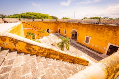 Campeche, Mexico - Yellow building with a courtyard and a staircase. The courtyard is empty and the building is old