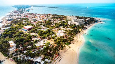 Isla Mujeres, Cancun, Mexico - Sahilde arka planda bir kasaba. Sahil insanlarla dolu ve birçok şemsiye var.
