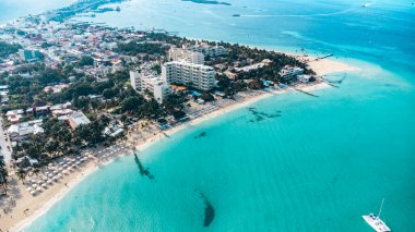 Isla Mujeres, Cancun, Meksika arka planda tatil köyü olan güzel bir sahil. Su mavi ve gökyüzü berrak.