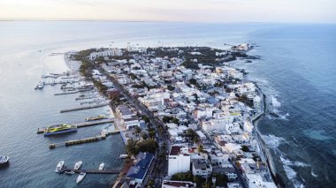 Isla Mujeres, Cancun, Mexico - Sahili ve arka planında su birikintisi olan şehir. Şehir binalarla dolu ve su sakin.