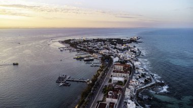 Isla Mujeres, Cancun, Meksika kıyıda küçük bir kasabası olan güzel bir okyanus manzarası. Gökyüzü turuncu ve mavi renklerin karışımıdır. Huzurlu ve huzurlu bir atmosfer yaratır.