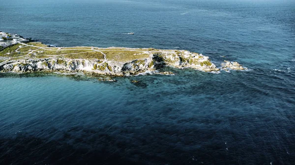Isla Mujeres, Cancun, Meksika - Rocky kıyıları, arkasında mavi bir okyanus var. Su sakin ve gökyüzü berrak.