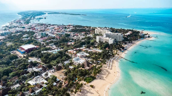 Isla Mujeres, Cancun, Mexico - Arkasında bir şehir olan plaj. Şehir küçük ve bir sürü binası var. Kumsal çok güzel ve üzerinde bir sürü insan var.
