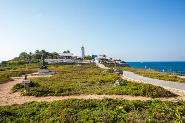 Isla Mujeres, Cancun, Meksika Sahili, deniz feneri ve bir kadın heykeli. Kumsal boş ve gökyüzü temiz.