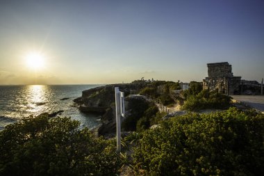 Isla Mujeres, Cancun, Meksika Güzel plajı kayalıklarda beyaz işareti olan. Güneş batıyor ve gökyüzü güzel bir mavi.