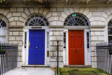 Londra, City, İngiltere, bir binada iki mavi ve kırmızı kapı. Mavi kapı solda ve kırmızı kapı sağda.