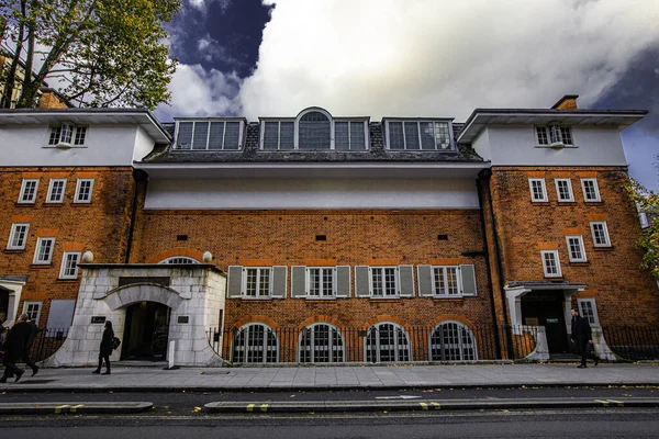 Londra, Şehir, İngiltere, beyaz kapısı ve penceresi olan tuğla bina. Bina yüksek ve bir sürü penceresi var.