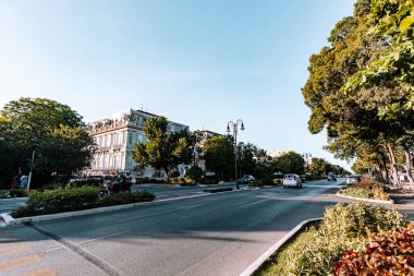 Merida, Yucatan, Meksika, Beyaz bir bina ve ağaçları olan cadde. Sokaklar boş ve gökyüzü mavi.