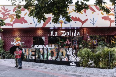 Merida, Yucatan, Meksika, La Dolida yazan renkli bir bina. Bina ağaçlarla çevrili ve tropikal bir havası var.
