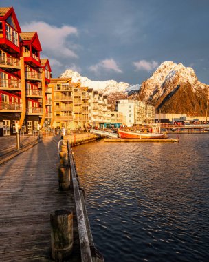Svolvear, Lofoten Adası, Norveç, bir nehir ve rıhtım. Rıhtım teknelerle dolu. Gökyüzü bulutlu.