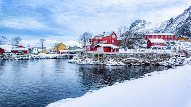 Svolvear, Lofoten Adası, Norveç 'in küçük bir kasabası. Nehir ve evleri var. Evler kırmızı ve sarı. Kar zemini kaplıyor.